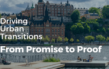 Scenic view of a city waterfront with old European-style buildings and green trees on a hill, with a wooden dock in the foreground and the white text overlay reading "Driving Urban Transitions From Promise to Proof.